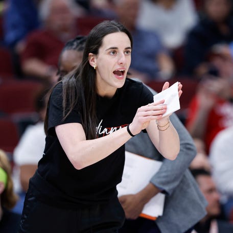 Indiana Fever guard Caitlin Clark (22) applauds her teammates during a WNBA game against the Chicago Sky.