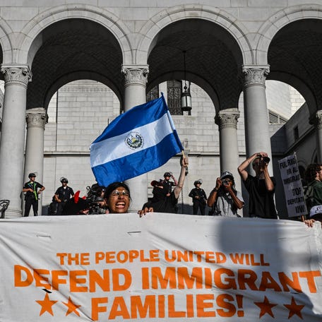 A protester waves a Salvadoran flag as people protest in front of Los Angeles City Hall against federal immigration operations on June 11, 2025. Protests against Donald Trump's harsh immigration policies spread on June 11 across the United States.