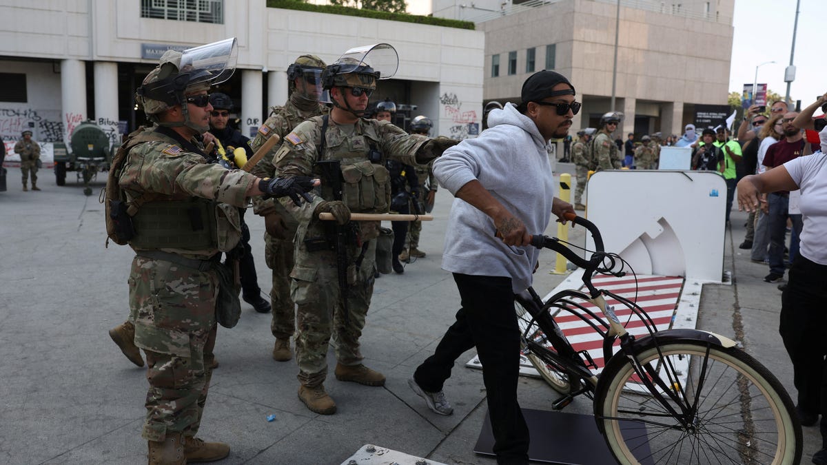 National Guard troops direct people away from a building in downtown Los Angeles.