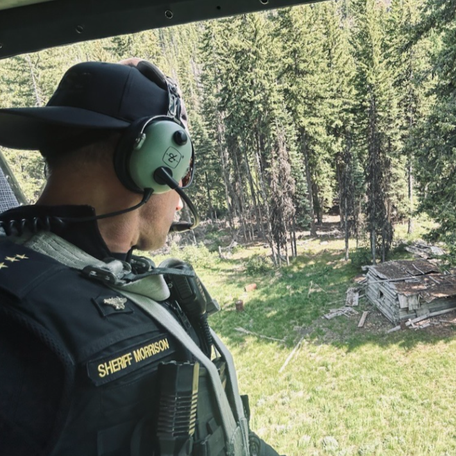 Chelan County Sheriff Mike Morrison looks out of a helicopter during law enforcement's hunt for Travis Decker on June 12, 2025.