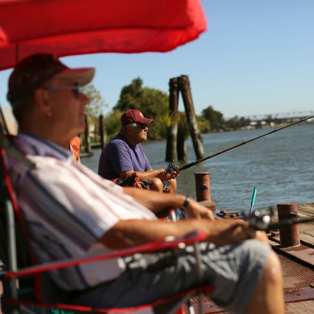 Retirees fish from a public dock on the Sacramento River in the Sacramento San Joaquin River Delta in Rio Vista. REUTERS/Robert Galbraith (UNITED STATES - Tags: AGRICULTURE ENVIRONMENT SOCIETY)