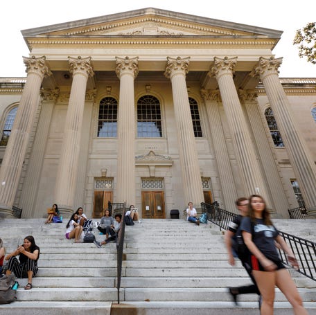 Students sit on the steps of Wilson Library on the campus of University of North Carolina at Chapel Hill in 2018.