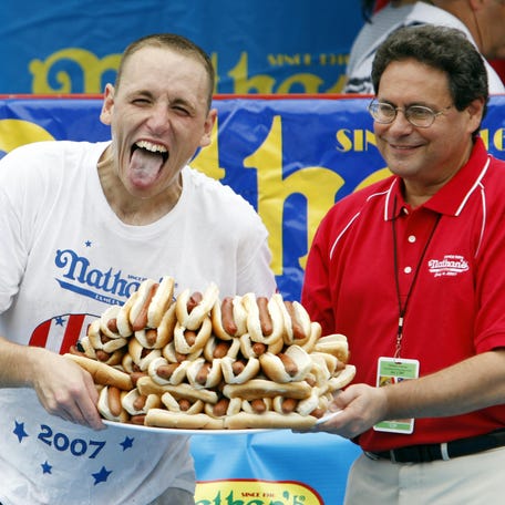 Joey Chestnut of San Jose, California celebrates winning the annual International July Fourth Hot Dog Eating Contest by holding a plate of 66 hot dogs and buns with an unidentified official July 4, 2007, at the original Nathan?s Famous restaurant in the Coney Island section of Brooklyn, NY. Chestnut won by eating 66 hot dogs in 12 minutes, a world record, beating defending and six-time champion Takeru Kobayashi of Nagano, Japan. The initial count was tied at 63 after the 12 minutes, but   judges awarded Chestnut 3 more hot dogs after counting their plates.