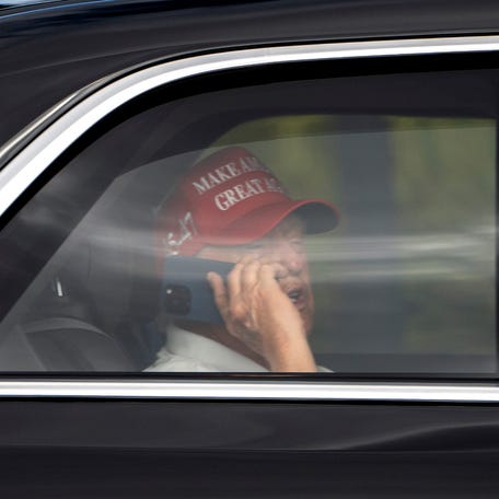 President Donald Trump talks on the phone as he arrives at Trump International Golf Club in West Palm Beach, Florida, on April 4, 2025.