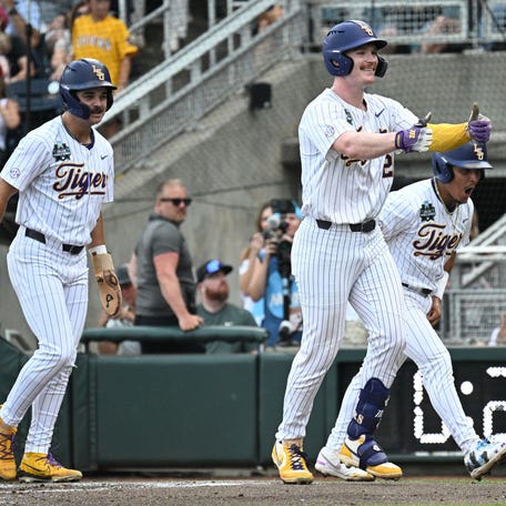 Jun 16, 2025; Omaha, Neb, USA; LSU Tigers first baseman Jared Jones (22) celebrates with shortstop Steven Milam (4) and right fielder Jake Brown (7) after hitting a three run home run against the UCLA Bruins at Charles Schwab Field. Mandatory Credit: Steven Branscombe-Imagn Images