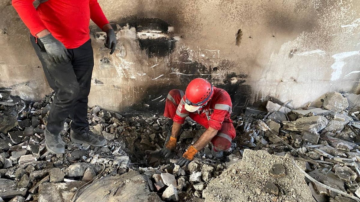 Iranian Red Crescent Society members search through the rubble for victims after Israeli strikes, at an unspecified location in Iran, in this undated image released June 17, 2025 and obtained from social media.