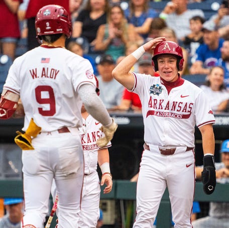 June 17: Arkansas' Wehiwa Aloy (9) is greeted at home plate by teammates Charles Davalan and Logan Maxwell after hitting a two-run home run against UCLA during the first inning at Charles Schwab Field. Arkansas won the game, 7-3, to advance to the semifinals.