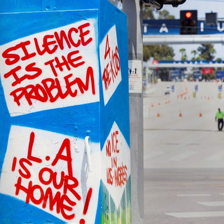 Protester Al Aguilar holds a sign outside Gate A of Dodger Stadium.