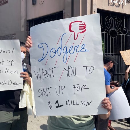 "Dodgers want you to shut up for $1 million" a protestor's sign reads.