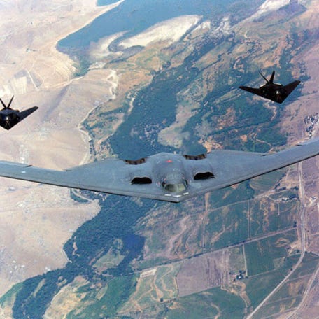 The B-2 spirit bomber, foreground, F-117A Nighthawks, background, fly during a training exercise in an undated photo.