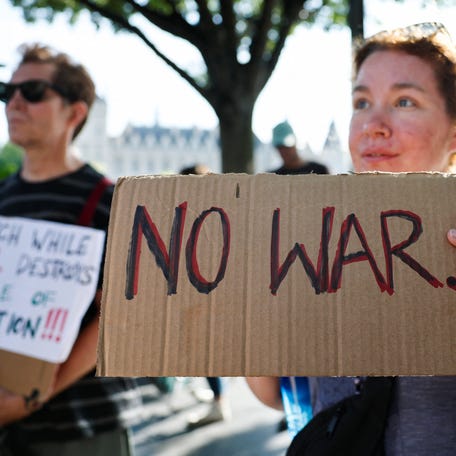 Protesters hold banners as Iranians in Paris demonstrate following the U.S attack on Iran's nuclear sites on June 22, 2025.