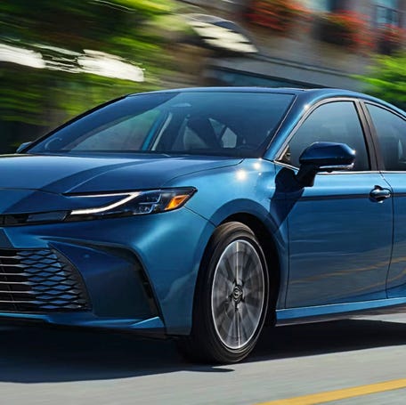 A blue 2025 Toyota Camry midsize hybrid car