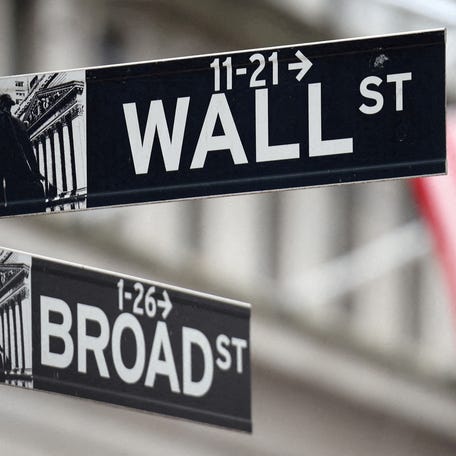 FILE PHOTO: A Wall Street sign hangs in front of a U.S. Flag outside the New York Stock Exchange (NYSE) before the Federal Reserve announcement in New York City, U.S., September 18, 2024. REUTERS/Andrew Kelly/File Photo