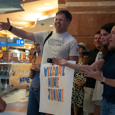 Brett Kurland (center) and Adrienne Kurland (right) greet their son, Jonah Kurland (left) as he arrives home at Phoenix Sky Harbor International Airport, on June 25, 2025. Seventeen Arizona high school students and two staff chaperones were evacuated from Israel and arrived home.