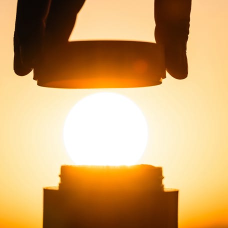 Stock image shows a bottle with a sun in the background.