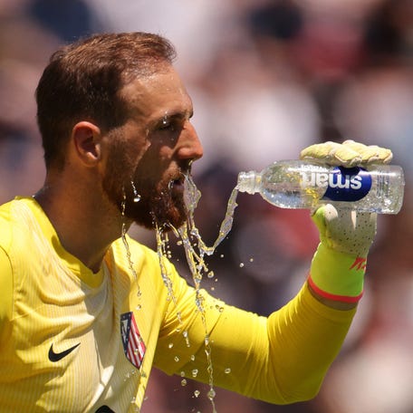 Atletico Madrid goalkeeper Jan Oblak pours water on his face to cool down during a break in play at the Rose Bowl.