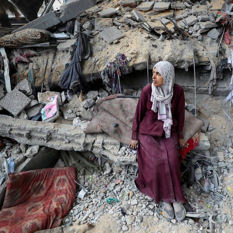 A Palestinian woman sits amidst the damage at an UNRWA school sheltering displaced people that was hit in an Israeli air strike on Sunday, in Gaza City, June 30, 2025.