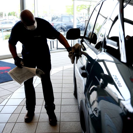 An Avis Ford employee polishes up a 2021 Ford Bronco Sport in the showroom at the car dealership in Southfield on Tuesday, June 8, 2021.