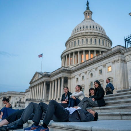 Senate staffers rest on the U.S. Capitol steps at sunrise as Republican lawmakers struggle to pass U.S. President Donald Trump's sweeping spending and tax bill, on Capitol Hill in Washington, D.C., U.S., July 1, 2025.