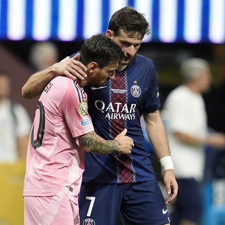 Inter Miami FC forward Lionel Messi (10) reacts with Paris Saint-Germain forward Khvicha Kvaratskhelia (7) during a round of 16 match of the 2025 FIFA Club World Cup at Mercedes-Benz Stadium.