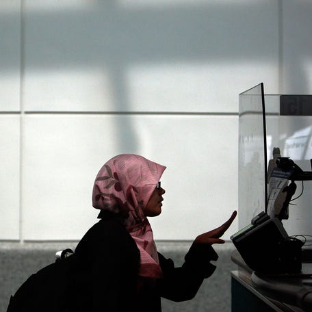 A traveler arriving from overseas is fingerprinted while his paperwork is checked in a passport control line upon arriving to Newark International Airport.