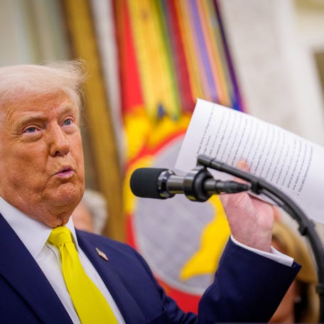 President Donald Trump holds up a document as he speaks during a swearing in ceremony for Dr. Mehmet Oz as Medicare and Medicaid Services Administrator in the Oval Office at the White House on April 18, 2025 in Washington, DC.