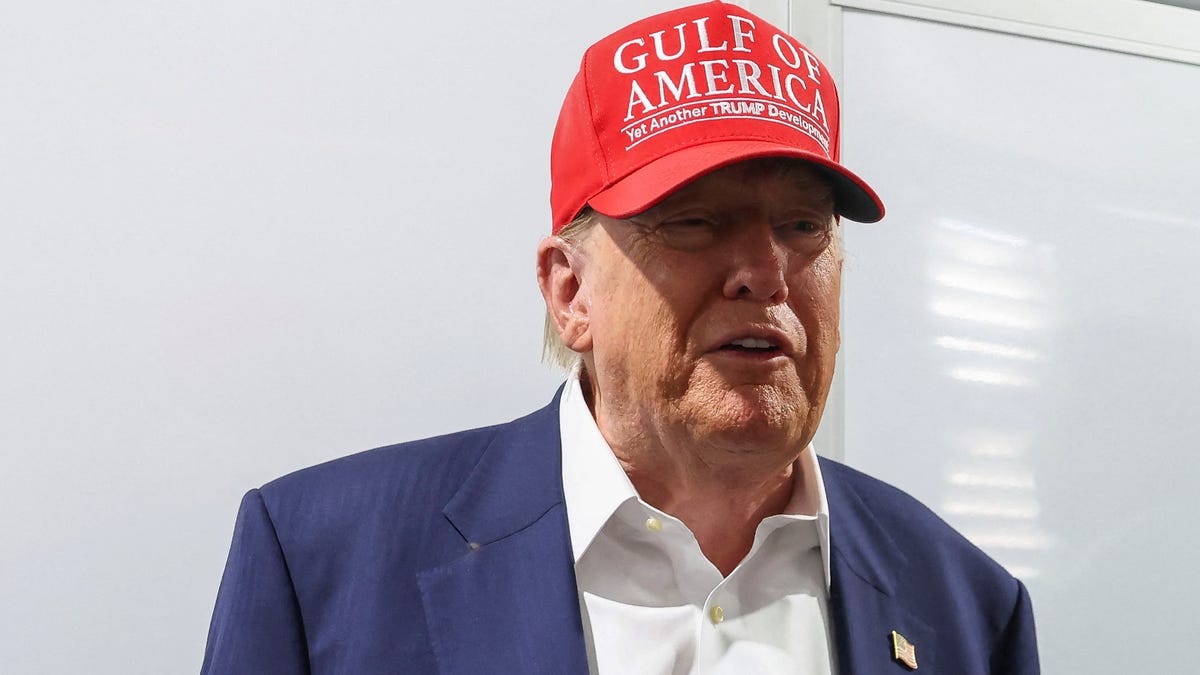 President Donald Trump gestures as he visits a medical tent at a temporary migrant detention center in Ochopee, Florida.