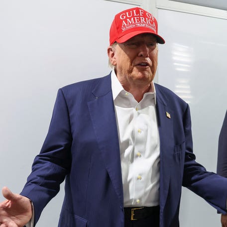 President Donald Trump gestures as he visits a medical tent at a temporary migrant detention center in Ochopee, Florida.