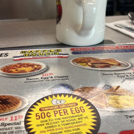 A menu in a Waffle House restaurant displays a sticker advising customers of a 50-cent price hike per egg "due to the nationwide rise in cost of eggs," in Houston, Texas, on February 6, 2025.