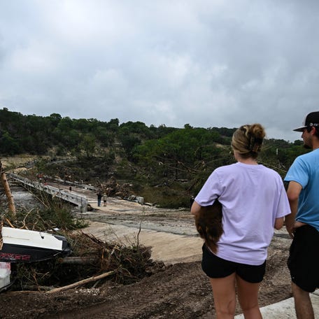 People look on as law enforcement and volunteers continue to search for missing people near Camp Mystic in Hunt, Texas, on July 5, 2025.