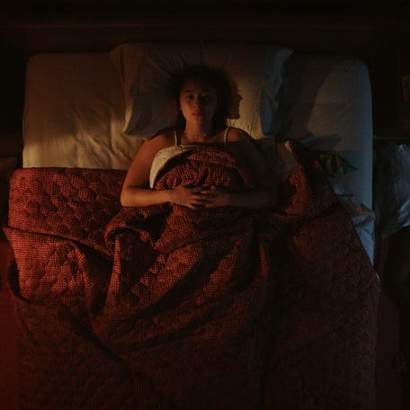 Conrad, Belly and Jeremiah seen laying side by side in a motel room.