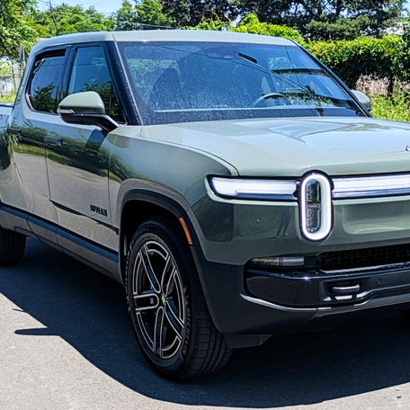 A Launch Green 2026 Rivian R1T Quad electric pickup truck is parked.
