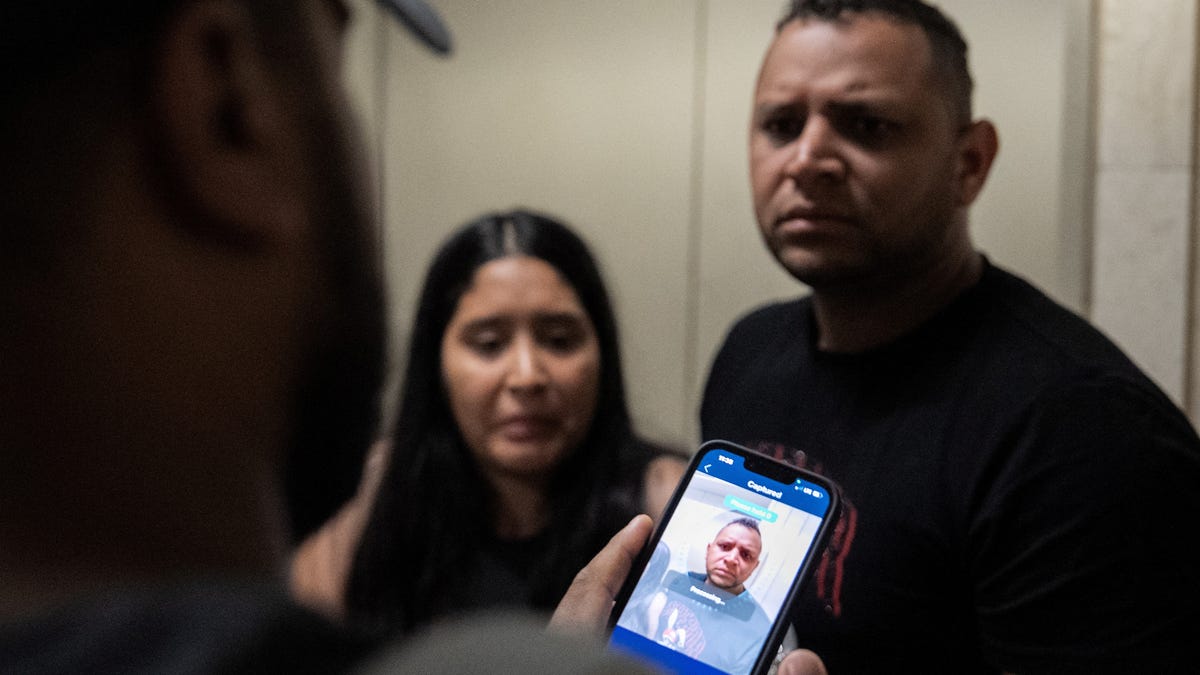 A federal immigration officer uses a facial recognition program on a person attending a hearing with his family; the individual is briefly detained before being released by federal immigration officers at U.S. immigration court in Manhattan, in New York City, U.S., June 30, 2025. REUTERS/David 'Dee' Delgado