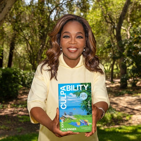 Oprah Winfrey holds a copy of her July book club pick, "Culpability."
