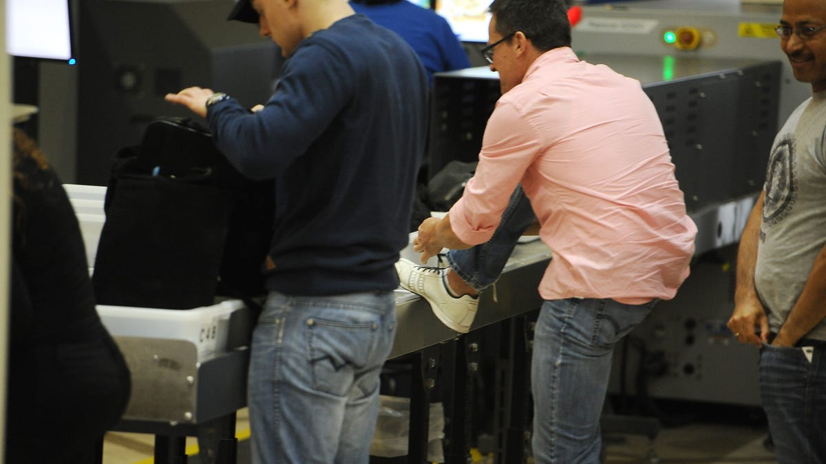 A traveler puts his shoes back on after passing through the Transportation Security Administration (TSA) security check at Los Angeles International Airport (LAX) on February 20, 2014 in Los Angeles, California.