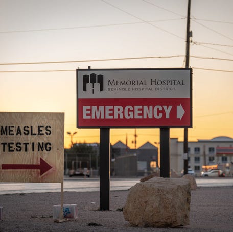 SEMINOLE, TEXAS - FEBRUARY 27: Signs point the way to measles testing in the parking lot of the Seminole Hospital District across from Wigwam Stadium on February 27, 2025 in Seminole, Texas.