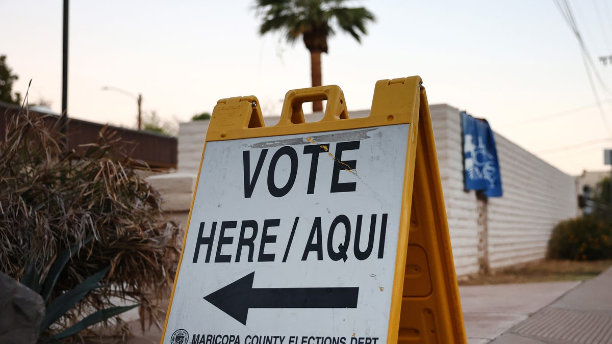 A Vote Here/Aqui sign is posted at a polling place at a church after the polls opened before sunrise on November 05, 2024 in Tempe, Arizona.