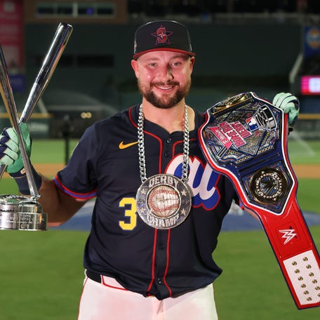 Cal Raleigh holds the Home Run Derby trophy after his victory at Truist Park.