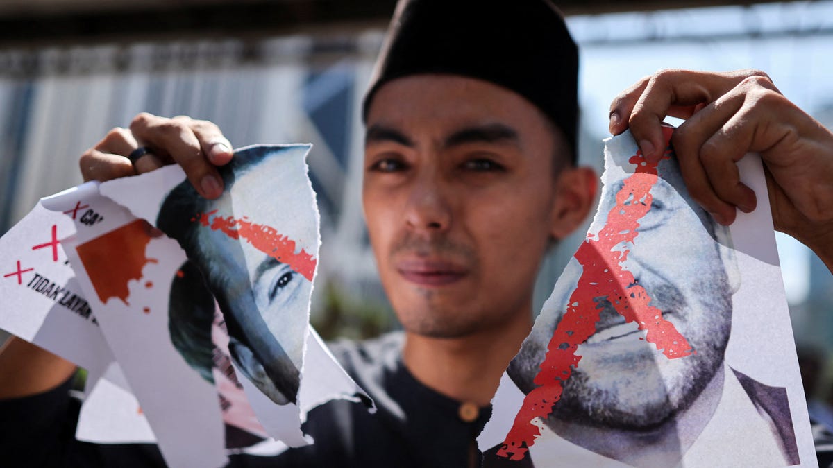A protester holds a torn picture of Nick Adams as he protests U.S. President Donald Trump's nomination of Nick as the U.S. ambassador to Malaysia, outside the U.S. Embassy in Kuala Lumpur, Malaysia July 18, 2025.