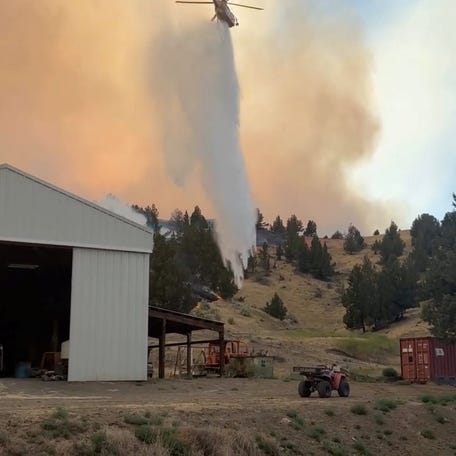A firefighting helicopter works to extinguish a wildfire in Jefferson County, Oregon.