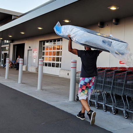 A customer carries back a mattress to Costco warehouse store in Toronto, Ontario, Canada September 14, 2018.
