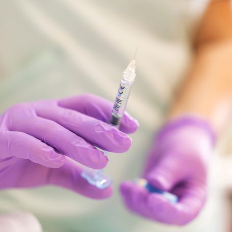 Unrecognizable female doctor holding a filler injection at the beauty clinic.