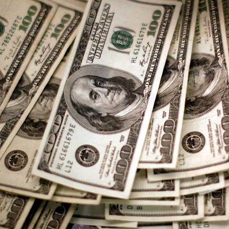 FILE PHOTO: Four thousand U.S. dollars are counted out by a banker counting currency at a bank in Westminster, Colorado November 3, 2009.