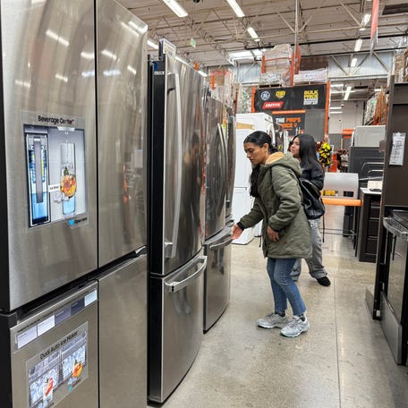 Customers inspect refrigerators displayed at a Home Depot store in San Rafael, California on March 31, 2025.