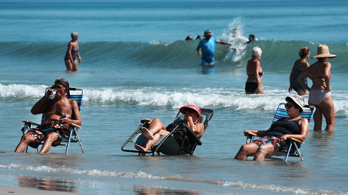 Beach goers in New Smyrna Beach beat the heat cooling off the the ocean, July 28, 2025 in front of the Flagler Avenue Beachfront Park.