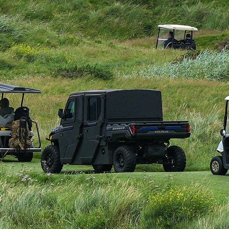 A cavalcade of golf buggies follow U.S. President Donald Trump plays as he plays a round of golf at Trump Turnberry golf course during his visit to the UK on July 27, 2025 in Turnberry, Scotland.
