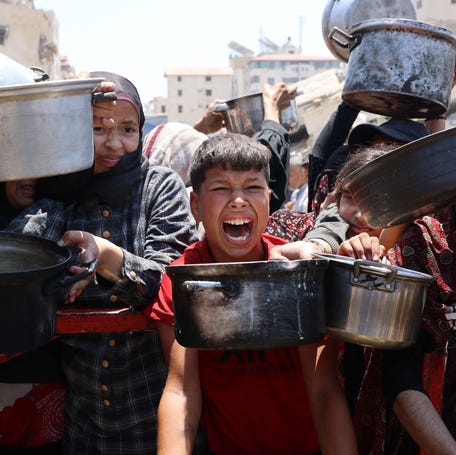 Palestinians crowd at a lentil soup distribution point in Gaza City in the northern Gaza Strip on July 27, 2025.