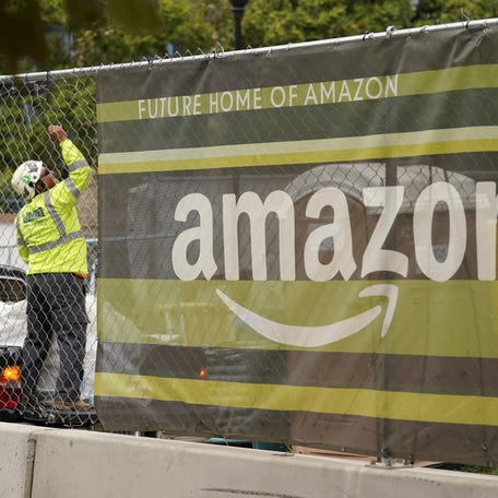 A sign hangs from a fence at Metropolitan Park, the first phase of new construction of Amazon's HQ2 development, in Arlington, Virginia, U.S., October 13, 2021.