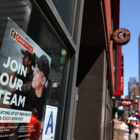 A sign for hire is posted on the window of a Chipolte Restaurant in New York City. REUTERS/Shannon Stapleton