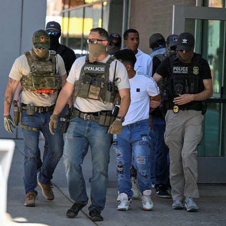 Law enforcement officers, including HSI and ICE agents, take people into custody at an immigration court in Phoenix, Arizona, U.S., May 21, 2025. REUTERS/Caitlin O'Hara  TPX IMAGES OF THE DAY